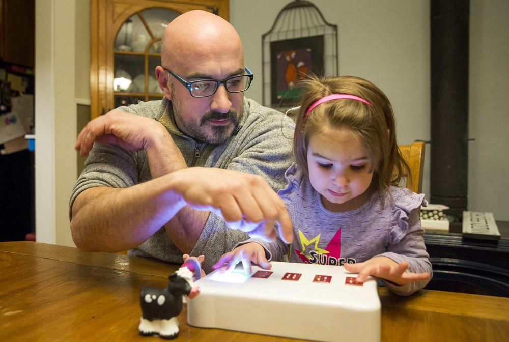 Jake Lacourse and his daughter Rebecca play with the BecDot. (Robin Lubbock/WBUR)