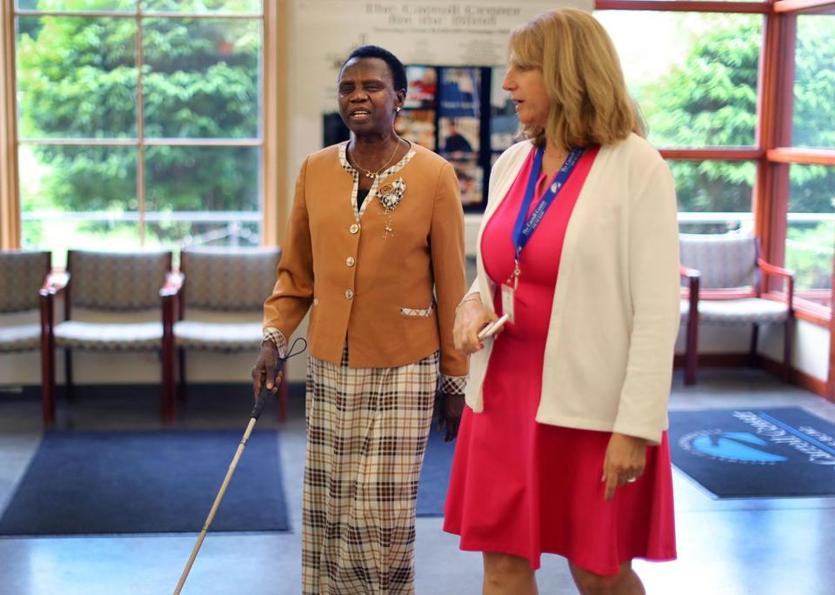 JOHN TLUMACKI/GLOBE STAFF Margaret Baba Diri walked in the lobby of the Carroll Center for the Blind in Newton with Dina Rosenbaum (right), chief program officer for the center.