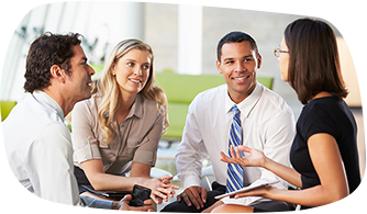 A group of four professionals discuss business together.