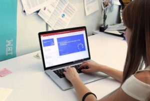 a young visually impaired woman works on a Powerpoint presentation.