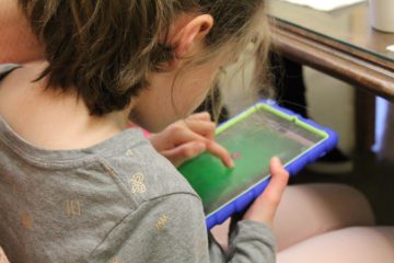 With an iPad in hand, a young visually impaired girl plays a new game designed to teach spacial skills called Barnyard.