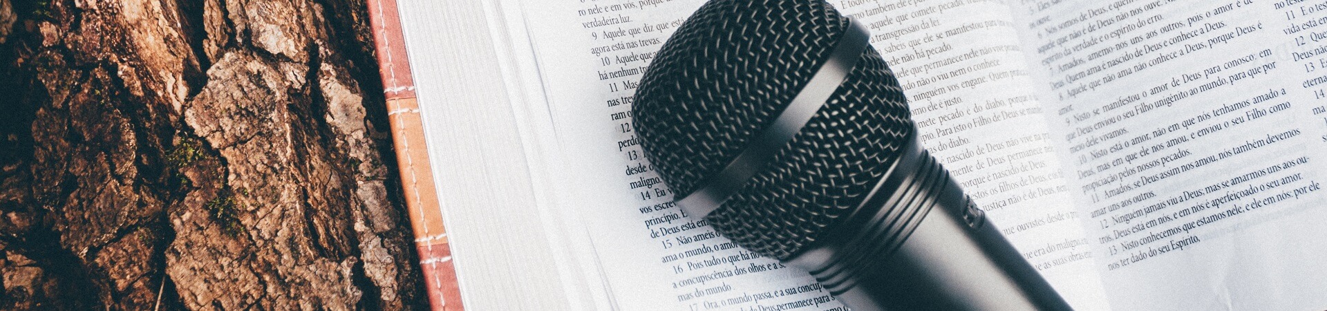 A black microphone rests atop an open book.