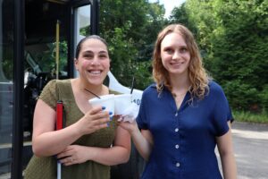 Photo of two staff members smiling and holding ice cream cups in front of an ice cream truck