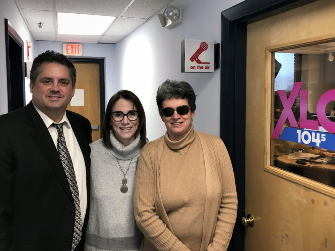 Three people pose outside the recording studio at XLO Radio. From left to right; Greg Donnelly, Vicki Greene and Jennifer Harnish.