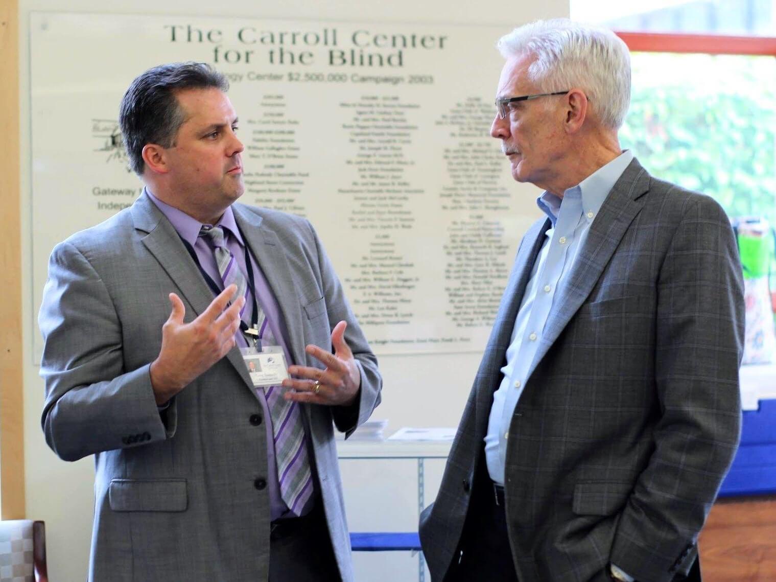 Gregory J. Donnelly (left), Carroll Center for the Blind President and CEO, talks with Thomas A. Croswell, Tufts Health Plan President and CEO in the lobby of the Rachel E. Rosenbaum Technology Center.