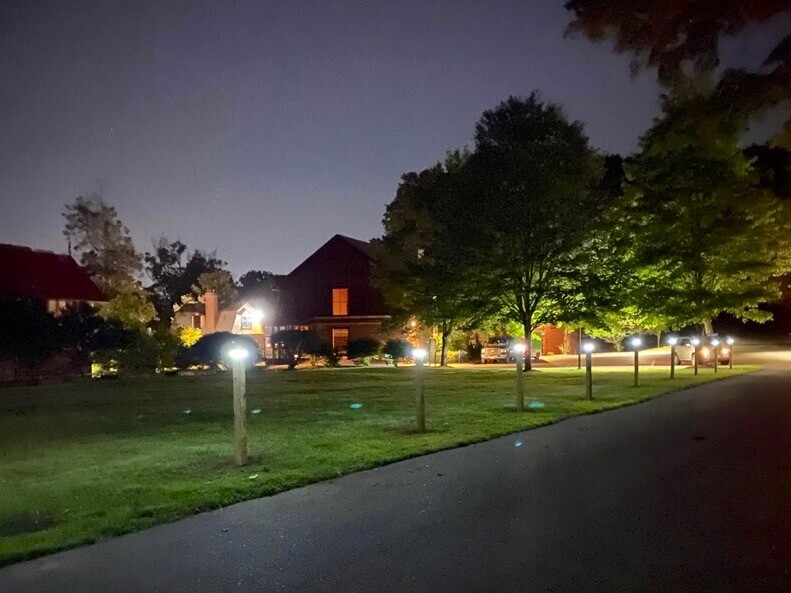 A completed Nearly a dozen illuminated solar light posts line the Carroll Center for the Blind driveway at dusk.