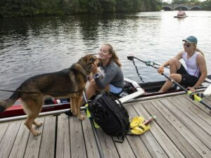 Para rower Pearl Outlaw greets her guide dog, Cinder, after early morning training with a new partner, Brooke Moss (right), on Sept. 28, 2021, in Brighton, Massachusetts.