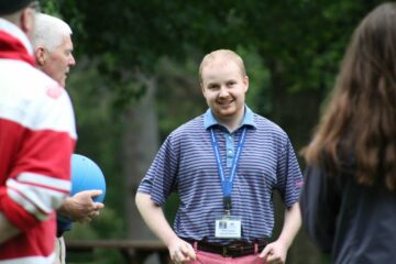 During Field Day activities on the lawn, a Carroll Center for the Blind instructor laughs while in a circle with students.
