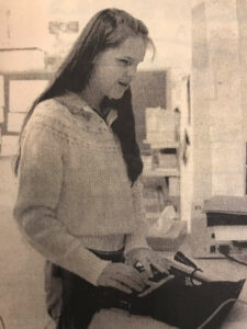 An old photo of a young Hope Paulos using a Braille N Speak.