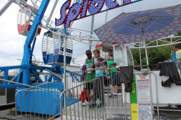 A man in a green shirt helping Carroll teen boy walk off Ferris wheel