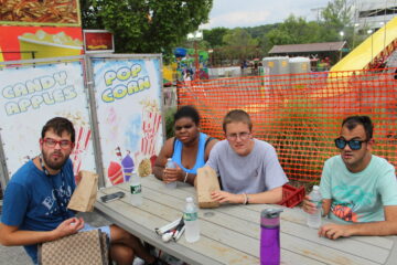 4 teens looking towards the camera on a picnic table