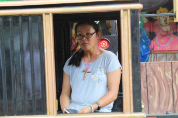Teen girl facing the camera in train cart with a blue shirt
