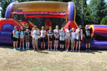 13 Carroll teens posing in front of bouncy house