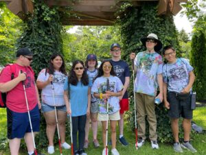Group of youth summer program participants pose together in a garden.