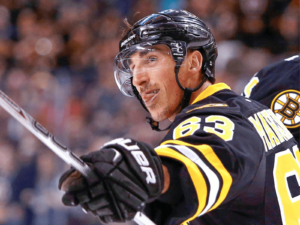 Brad Marchand of the Boston Bruins holds up his hockey stick during a game.