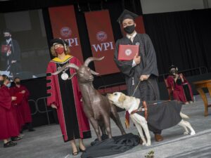 Jack Duffy-Protentis and Adonis, his white lab guide dog, receive his diploma at WPI commencement 2021