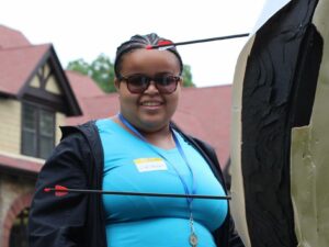 During her time in the Carroll Center's summer program, Lirianni German smiles as she collects her arrows from the target during Archery.