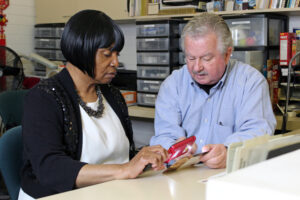 Low vision instructor showing a client how to use a portable magnifier