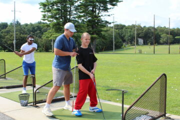 Carroll Center instructor helping a student during golf practice