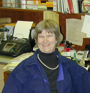 Smiling Michele Aldrich sitting at her desk