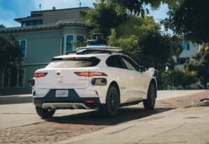 A white Waymo car in the city