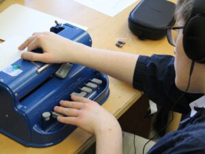 Carroll Center student typing on a brailler