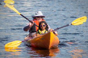 Carroll Center client kayaking with an instructor during a field trip