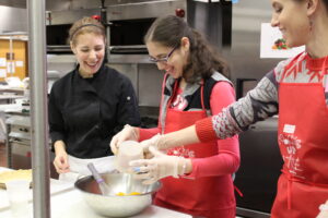 Carroll Center instructors showing a client non-visual cooking techniques