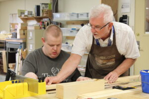 Carroll Center sensory arts instructor during a woodworking lesson with a client
