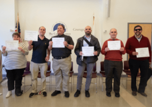 A group of Screen Reader User Tester program graduates holding certificates of completion