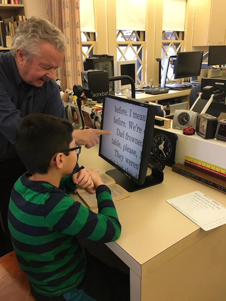 Bob McGillivray, Certified Low Vision Therapist at The Carroll Center for the Blind, is instructing a teen on how to use a desktop magnifier at the Center’s Low Vision Clinic.