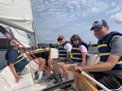4 SailBlind sailors smiling on a boat