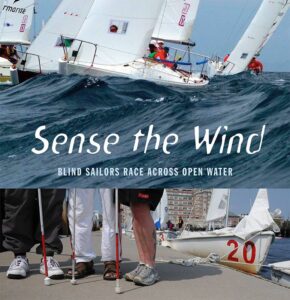 Sense the Wind film cover image with blind sailors standing the the sailboat and text that says "sense the wind - Blind sailors race across open water"