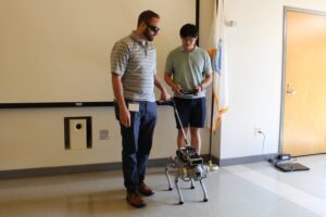 Robot guide dog researcher with a participant who is walking the robot guide dog