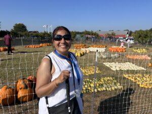 Carroll Alumna Pumpkin Picking Carroll alumna standing in front of a field of pumpkins and smiling