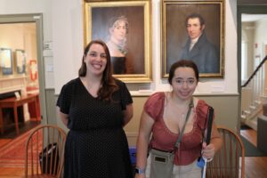 A young girl smiling next to her supervisor at the Historic Newton museum