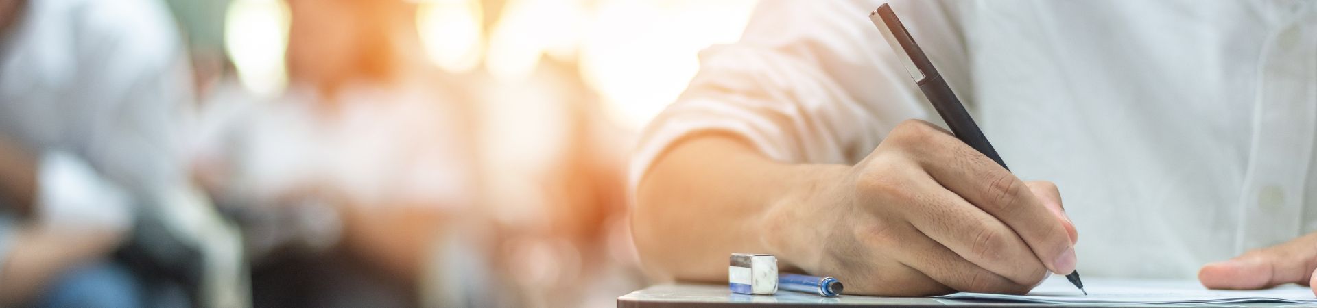 A room of people taking a written exam at separate tables