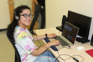 Teen girl smiling while studying on the computer