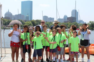 Group of young Summer Program participants posing for a photo at the Charles River Waterfront