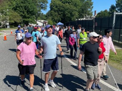 photo of sailor, Tim, walking with his mother at the Walk for Independence event on pavement. Next to Tim is sailor, Pardis, with husband Fred walking together.