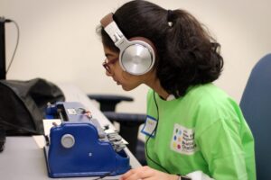 Ed Services Photo - Braille Challenge student Braille Challenge participant is using a brailler and has headphones on.
