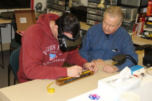Low vision therapist is working with a client who is using assistive technology glasses.