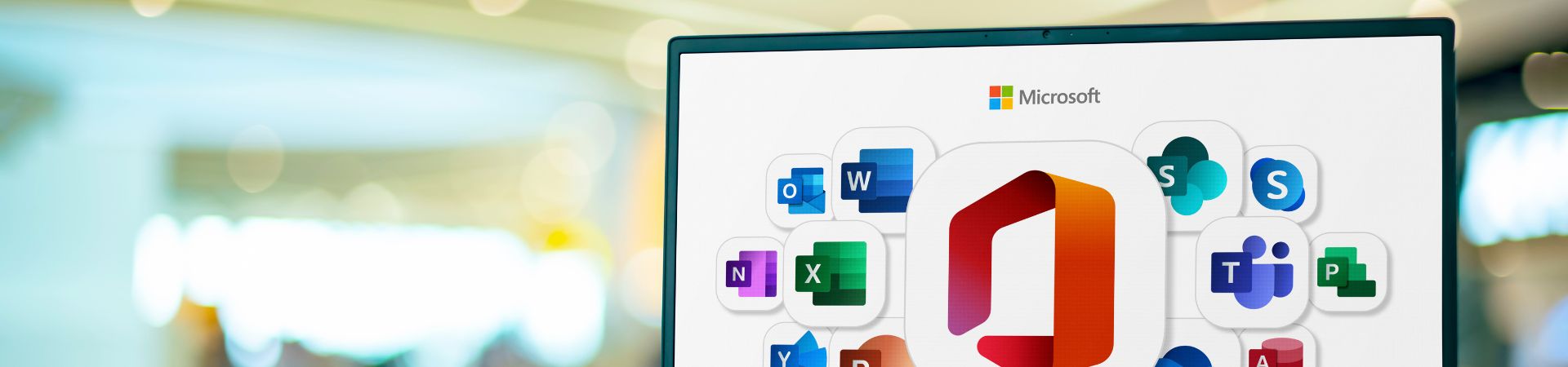 Part of laptop screen is shown with many Microsoft icons. The background is bright and blurred to showfocus on the screen.