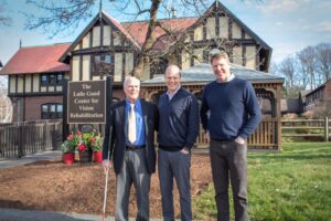 The Lulie Gund Center for Vision Rehabilitation Sign group photo Group photo of three men in front of the Lulie Gund Center for Vision Rehabilitation building.